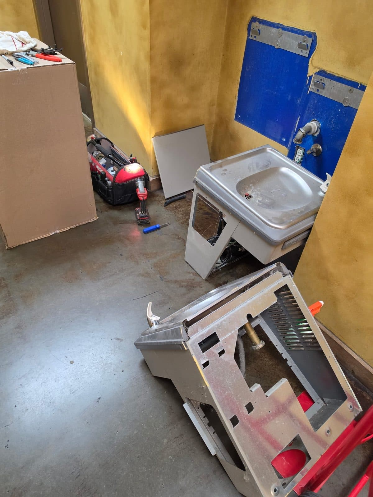 Wall-mounted stainless steel drinking fountain installation in a commercial building